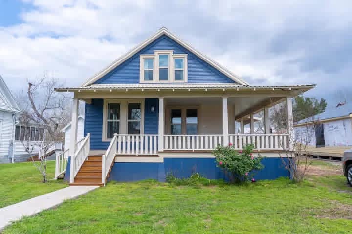 Historic blue cottage restoration with wrap-around porch